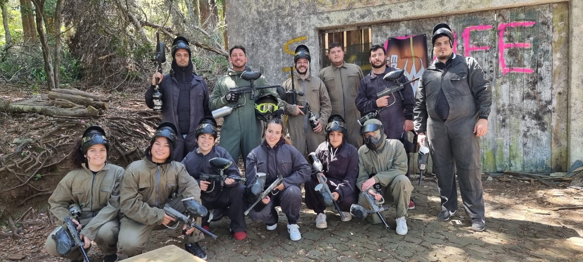 Grupo grande de jogadores de paintball em fotografia de equipa no campo